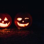 Zwei grinsende Jack O'Lanterns leuchten im Dunkeln.