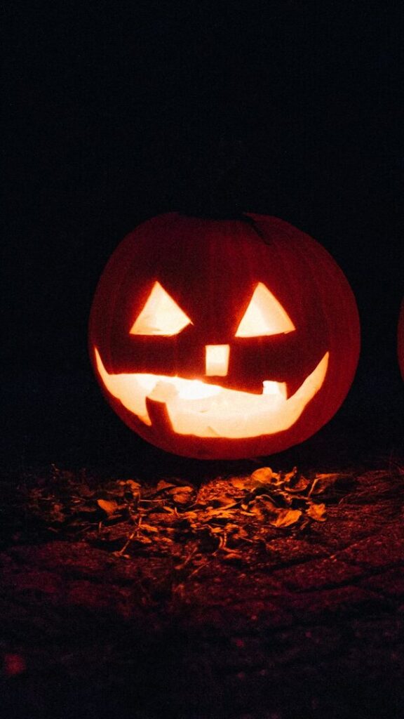 Ein grinsender Jack O'Lantern leuchtet im Dunkeln.